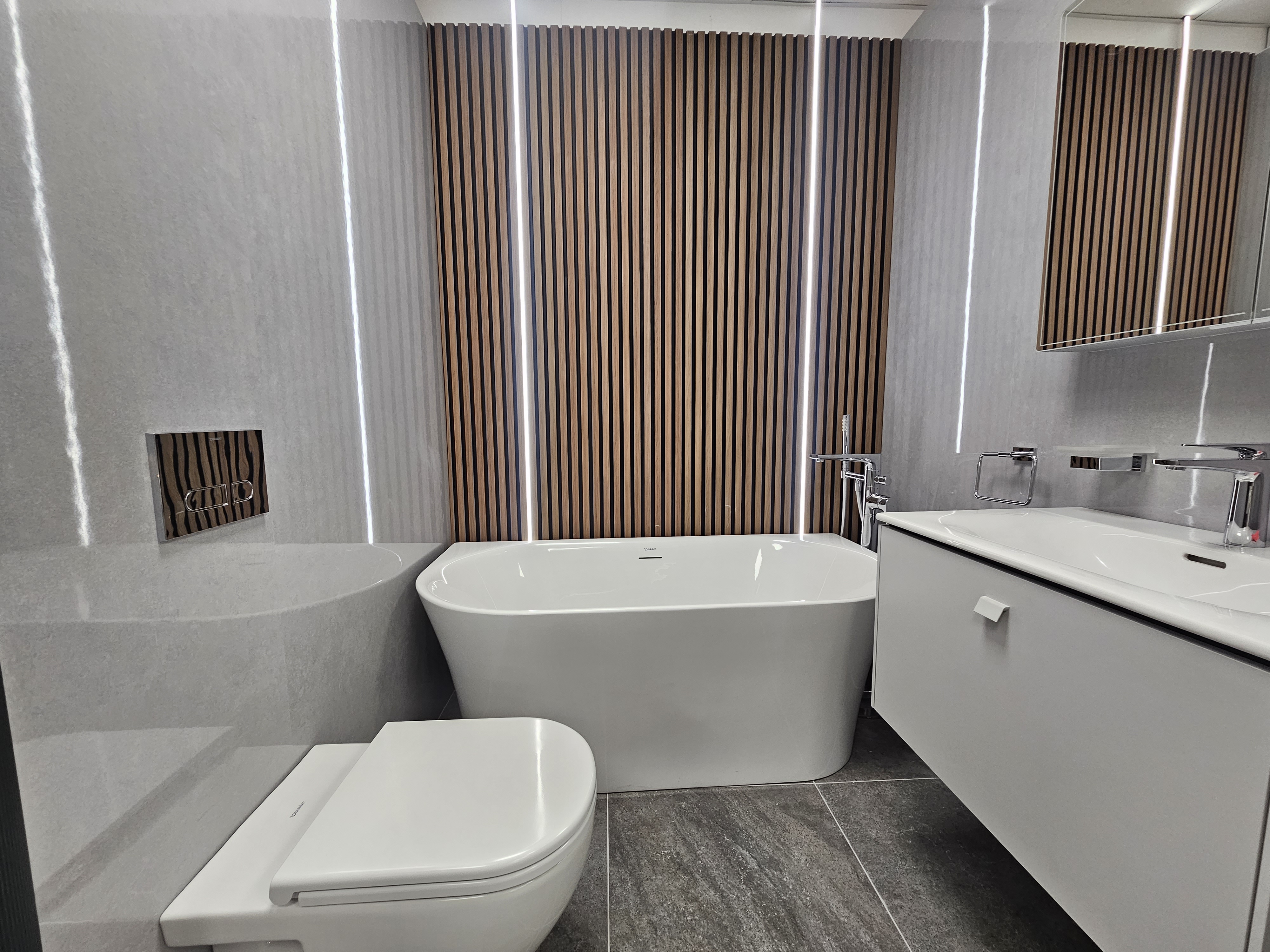 Bathroom display featuring a basin, vanity unit and coordinated finishes